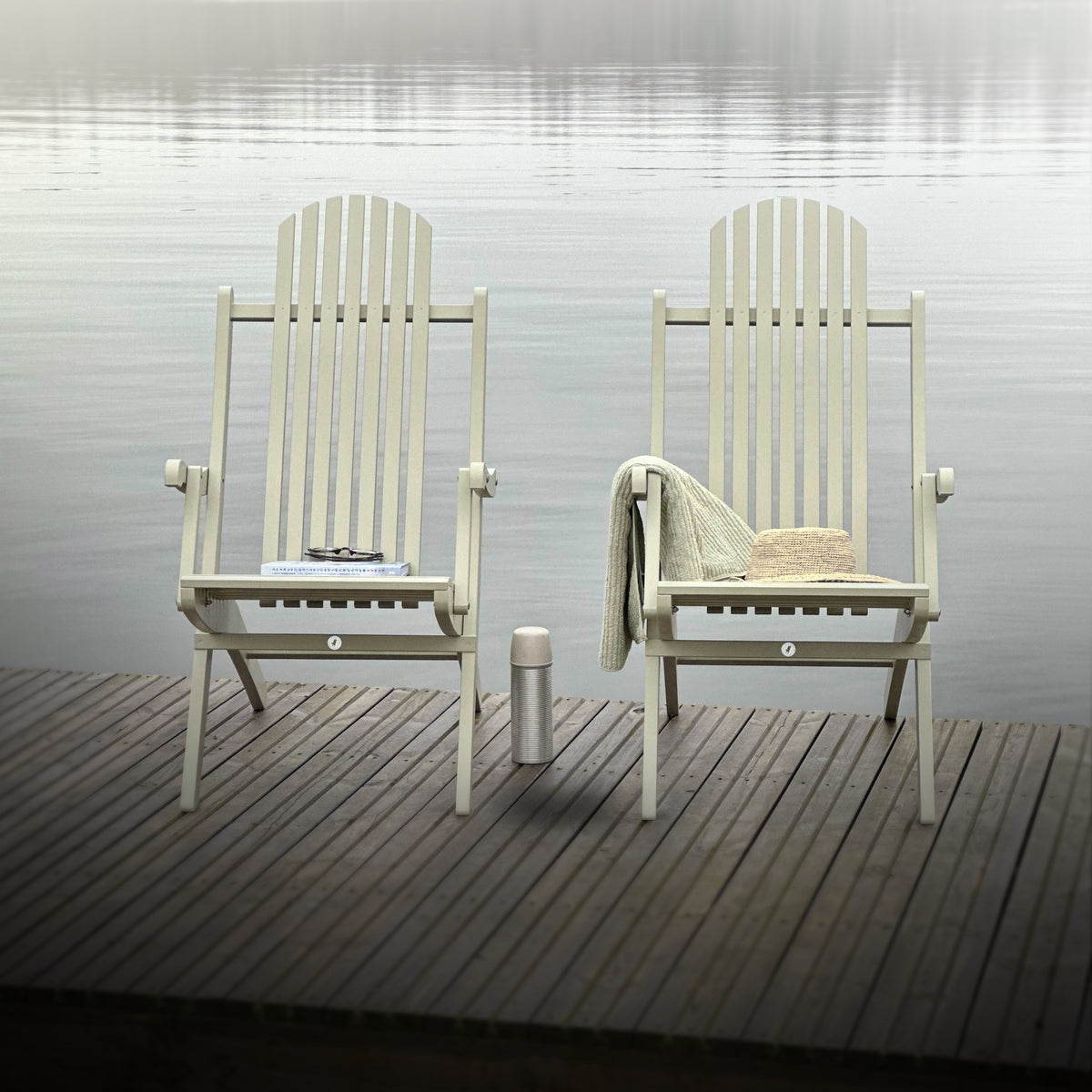 Två däckstolar på brygga, klassiska utemöbler i trä för utomhusbruk.