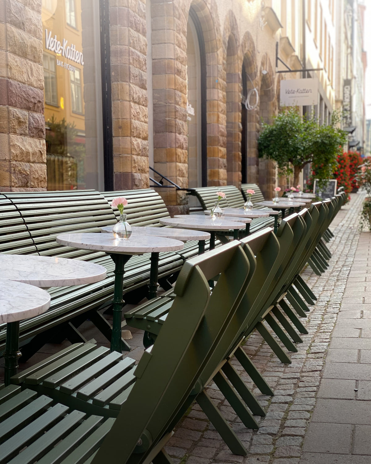 Vetekattens uteservering i Stockholm med marmorbord, Solbacka-stolar och Sundborn-soffor, klassiska trädgårdsmöbler.