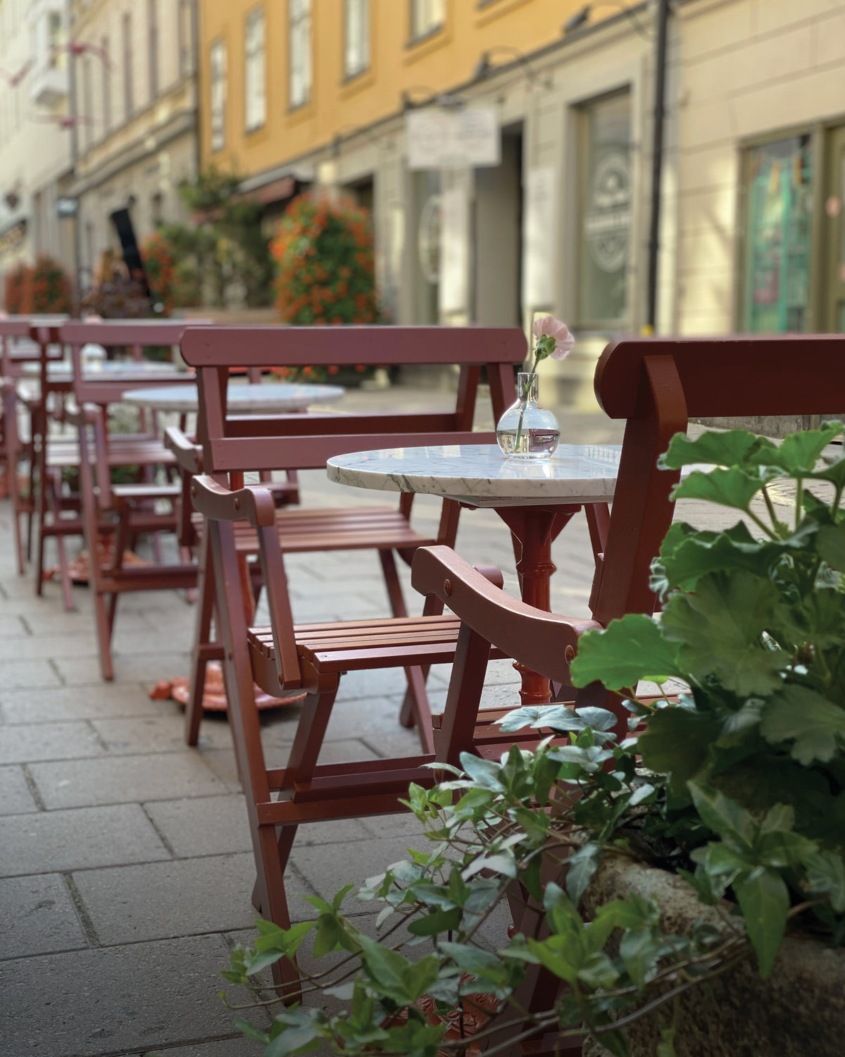 Röda Solbacka karmstolar på Vetekattens uteservering i Stockholm.