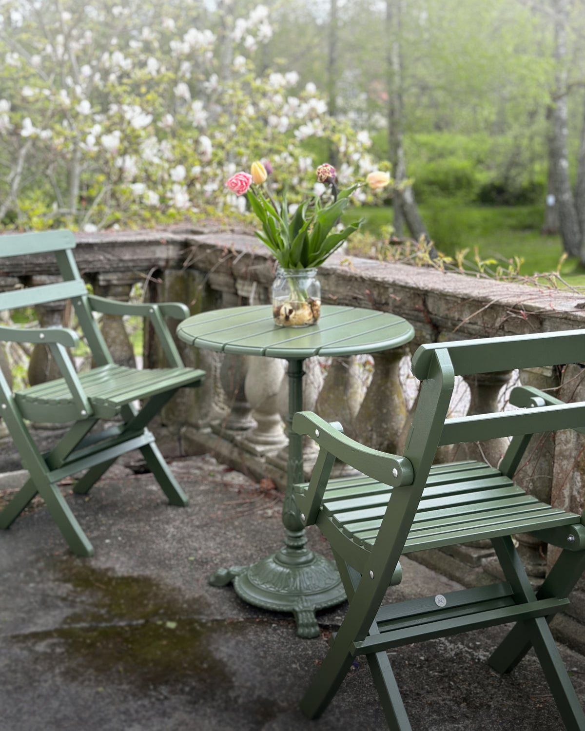 Cafebord med utestolar med armstöd, trädgårdsmöbler för uteservering och utomhusmiljö.