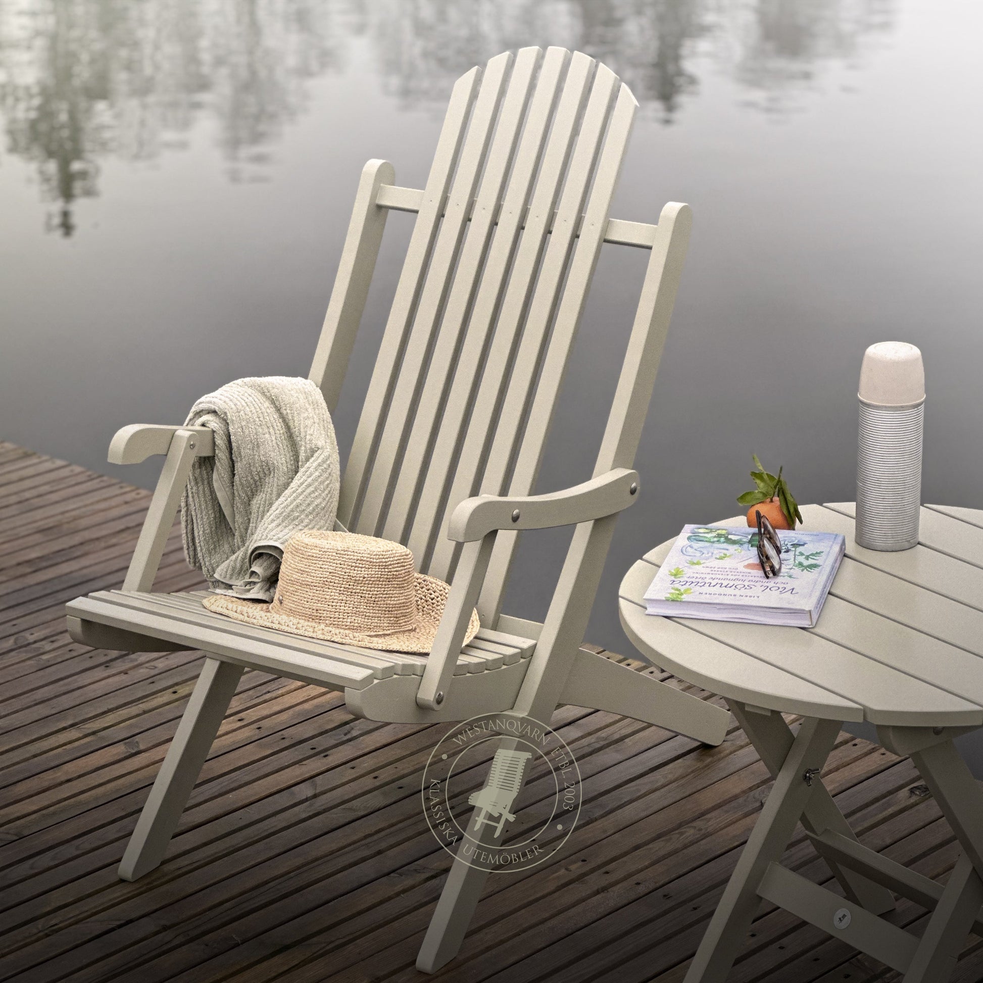 Däckstol Veranda i trä med loungebord på brygga vid en sjö